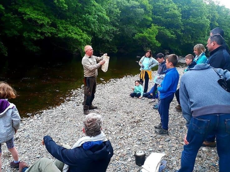 Outdoor river instruction with group learning bushcraft by water