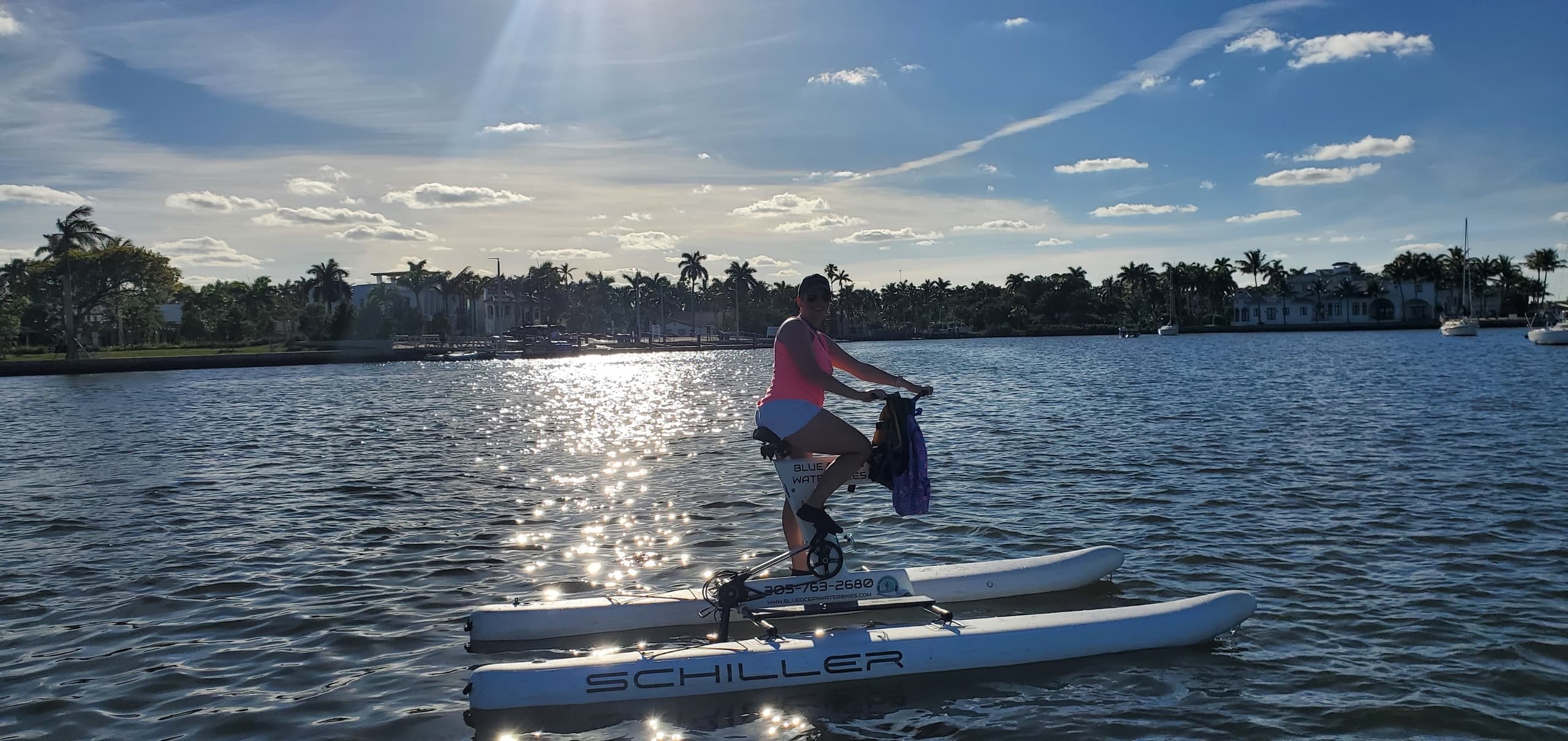 Solo rider on water bike at sunset over coastal inlet