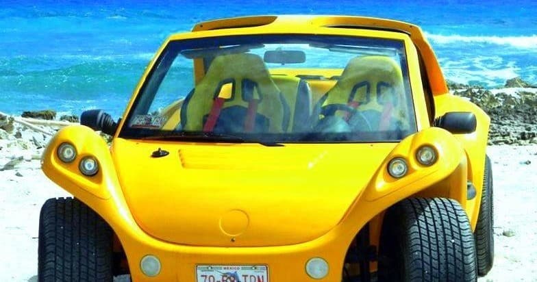 Bright yellow beach buggy parked on sandy seaside in Cozumel