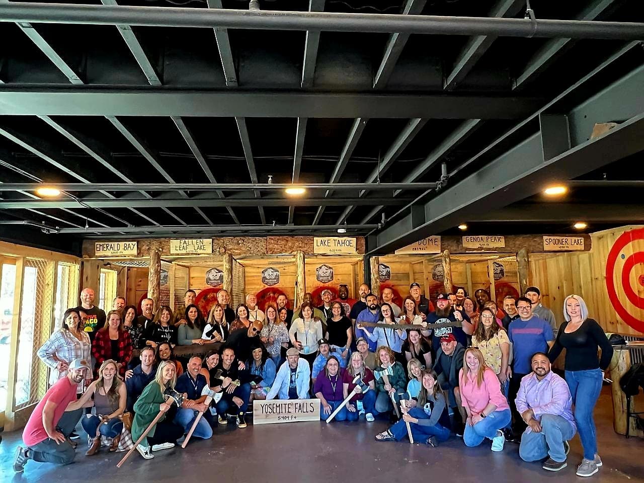 Large mixed group posing after indoor axe throwing in Tahoe