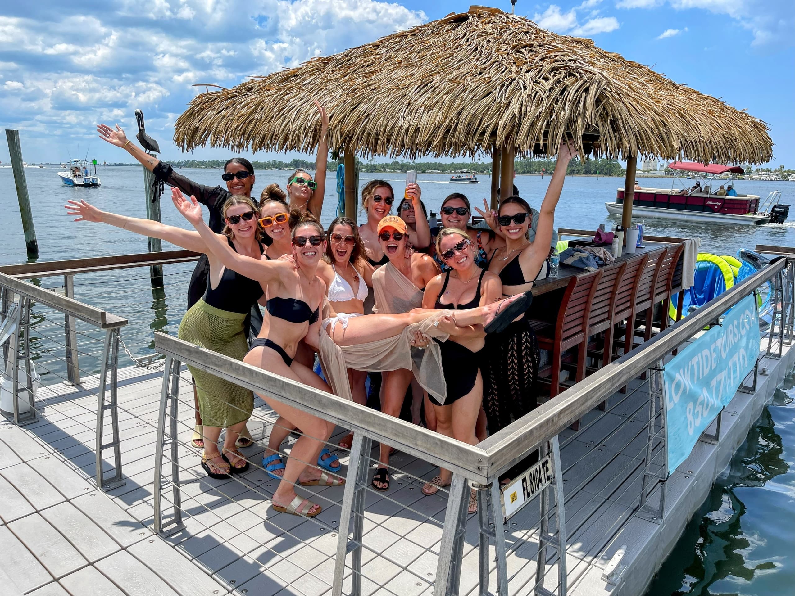 Group enjoying tiki bar dock on emerald coastal waters