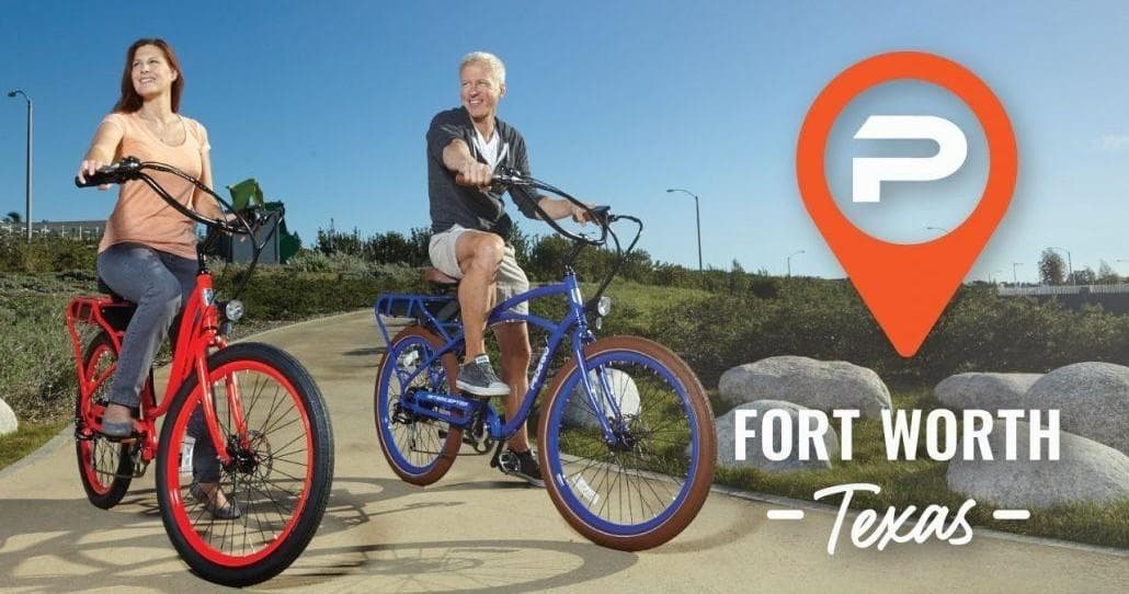 Two riders on electric bikes enjoying a sunny Fort Worth trail
