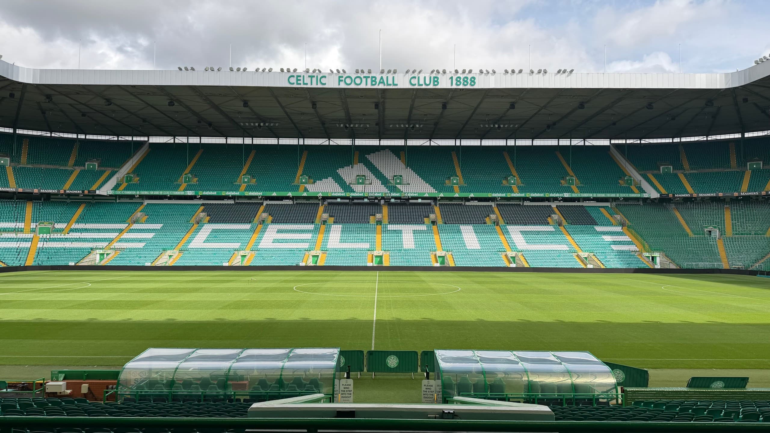 Wide stadium bowl view of Celtic Park under cloudy sky