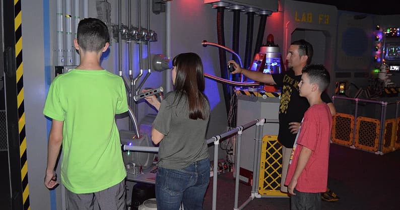 Group of kids interacting with hands-on sci-fi control exhibit