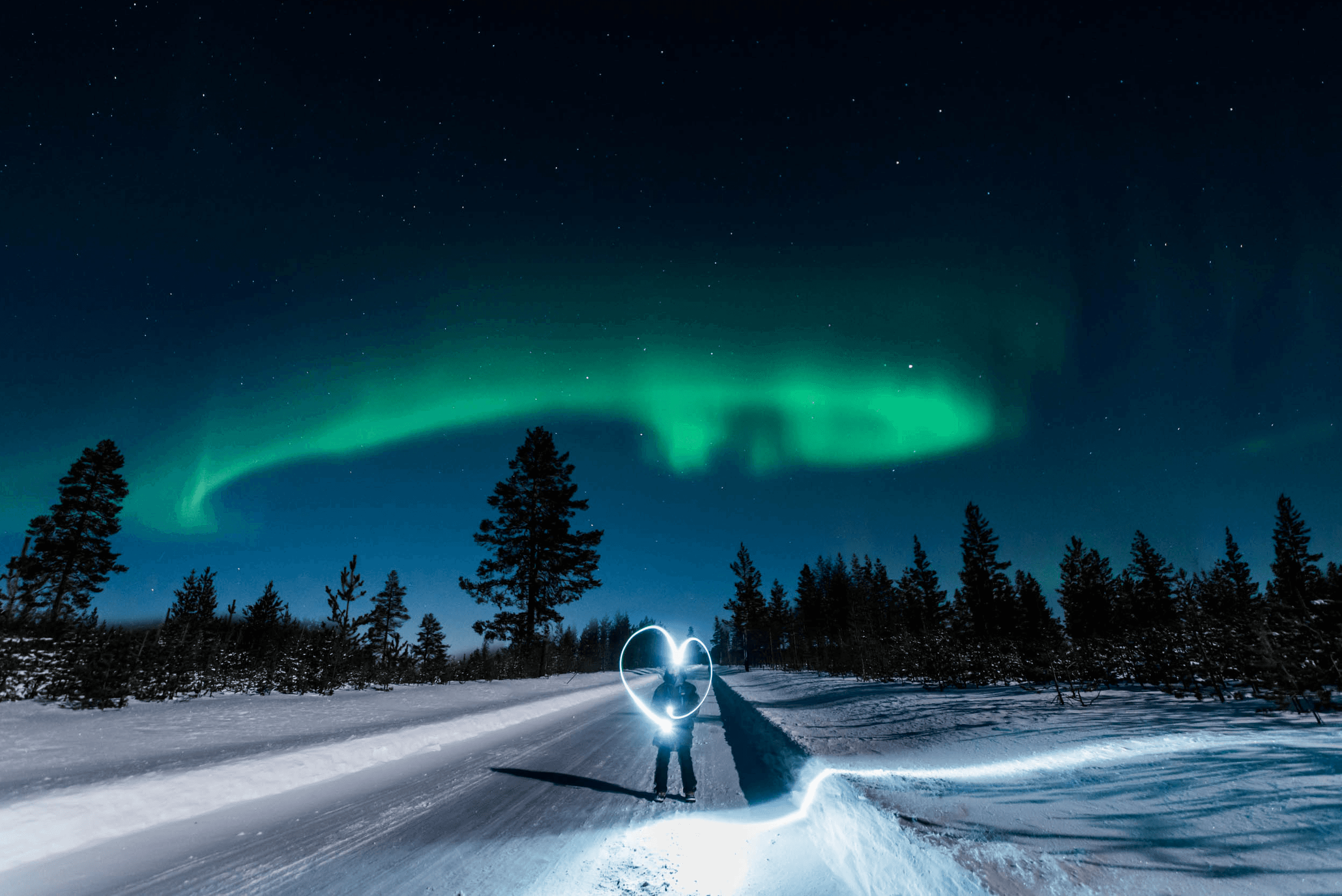 Snowmobile under northern lights on snowy Arctic road