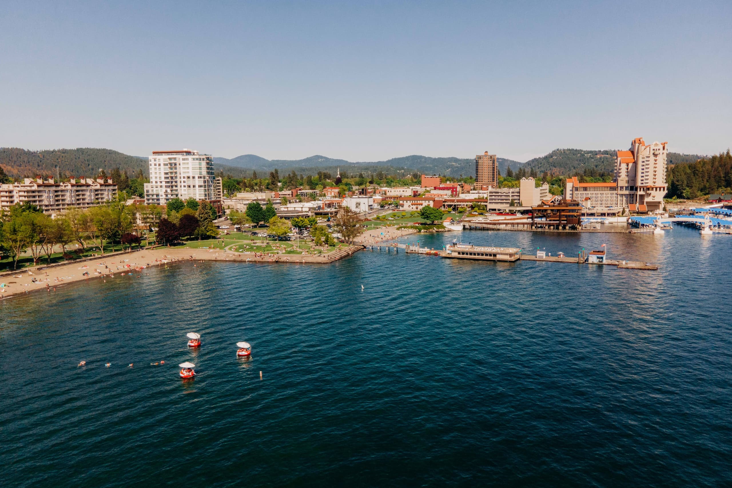 Coastal resort and marina from drone over clear blue lake water