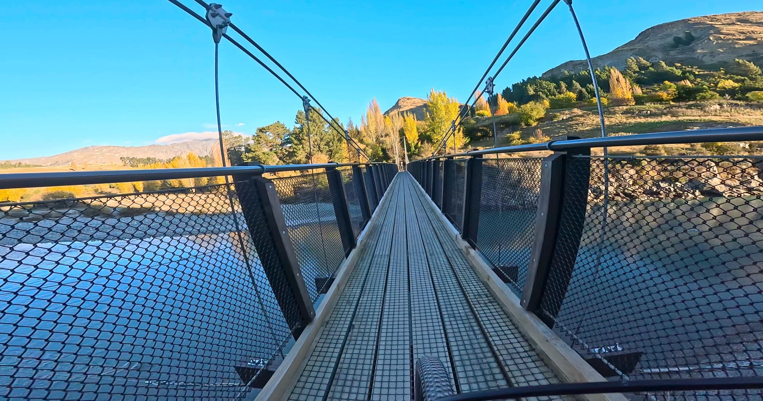 Suspension footbridge with leading lines over river valley