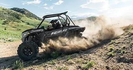 UTV tearing through grassy mountain trails, dusty action