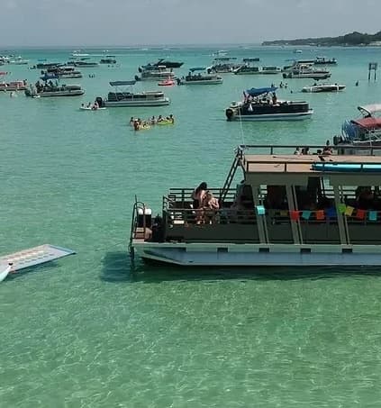Crowded party boats on clear turquoise shallow waters