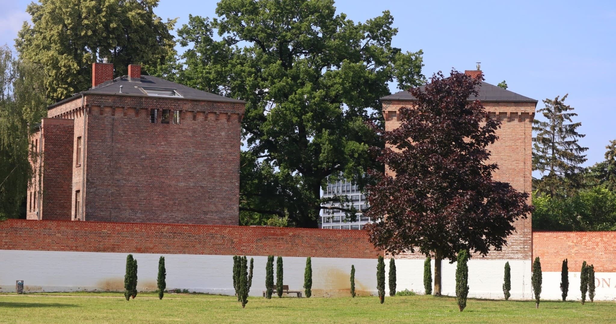 Historic brick fortress with expansive lawn and trees outdoors