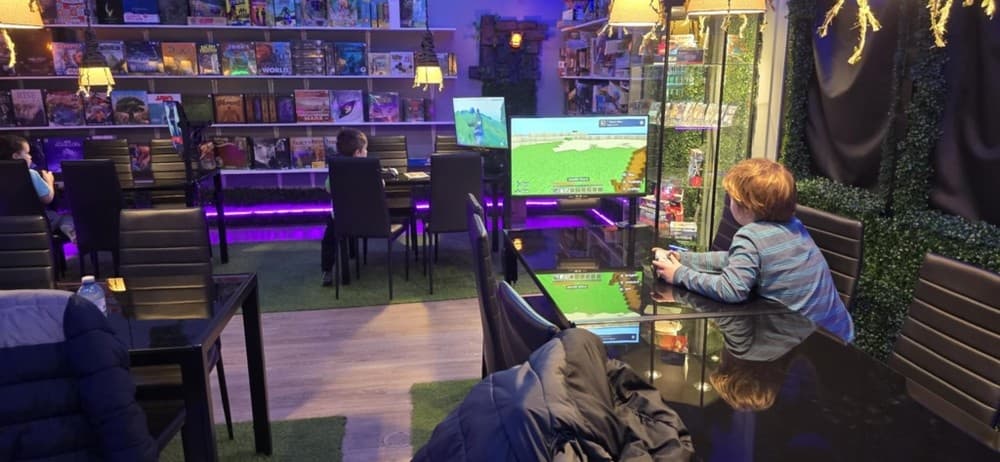 Open gaming lounge interior with tables and ambient purple lighting