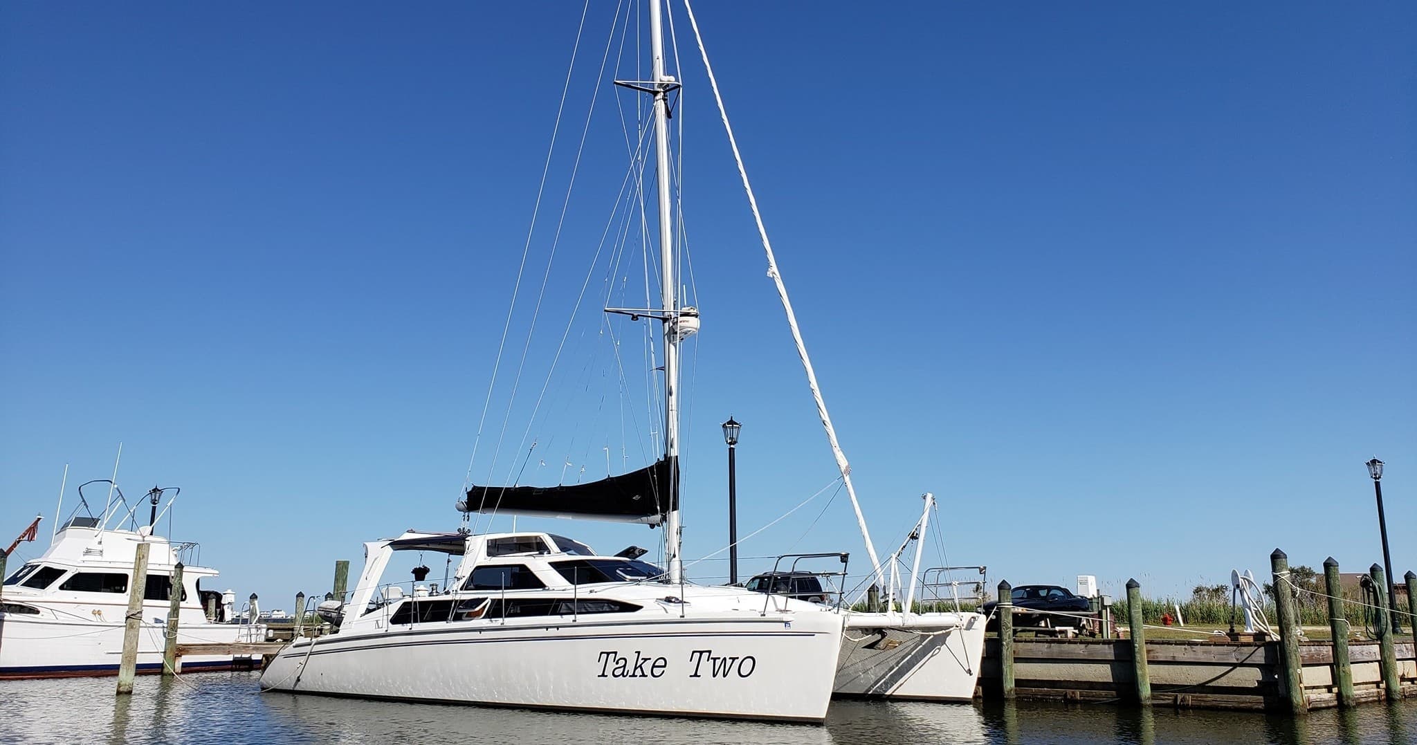 Docked catamaran at marina under clear blue daytime sky