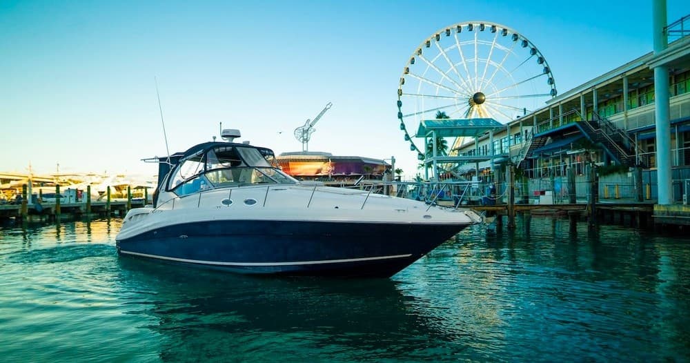 Motorboat docked by pier and Ferris wheel at coastal pier