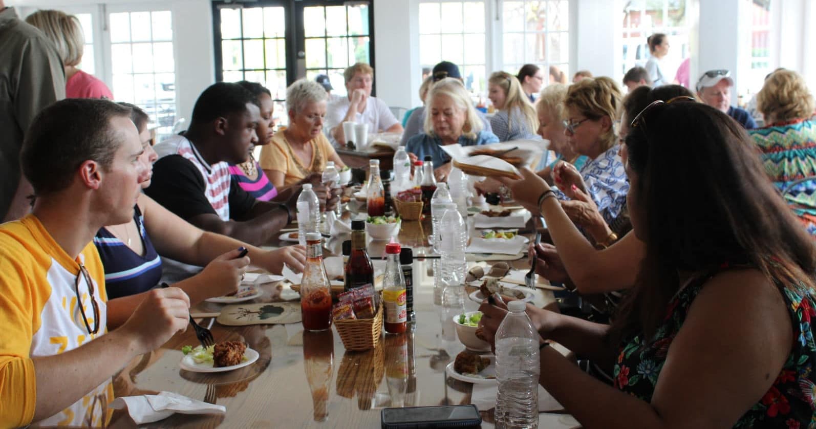 Large group tasting southern cuisine indoors at communal table