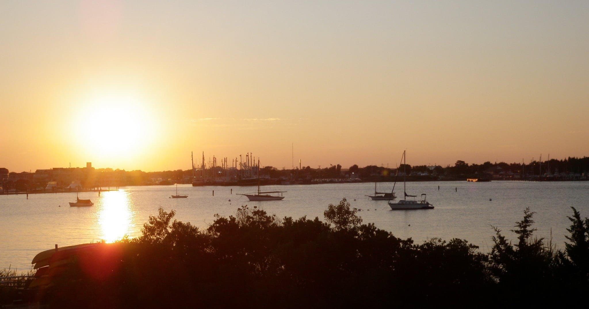Sunset harbor with kayaks and boats on calm water
