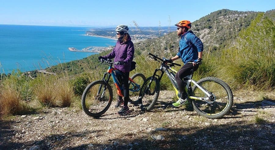 Two riders on electric bikes enjoying Mediterranean coastal trail