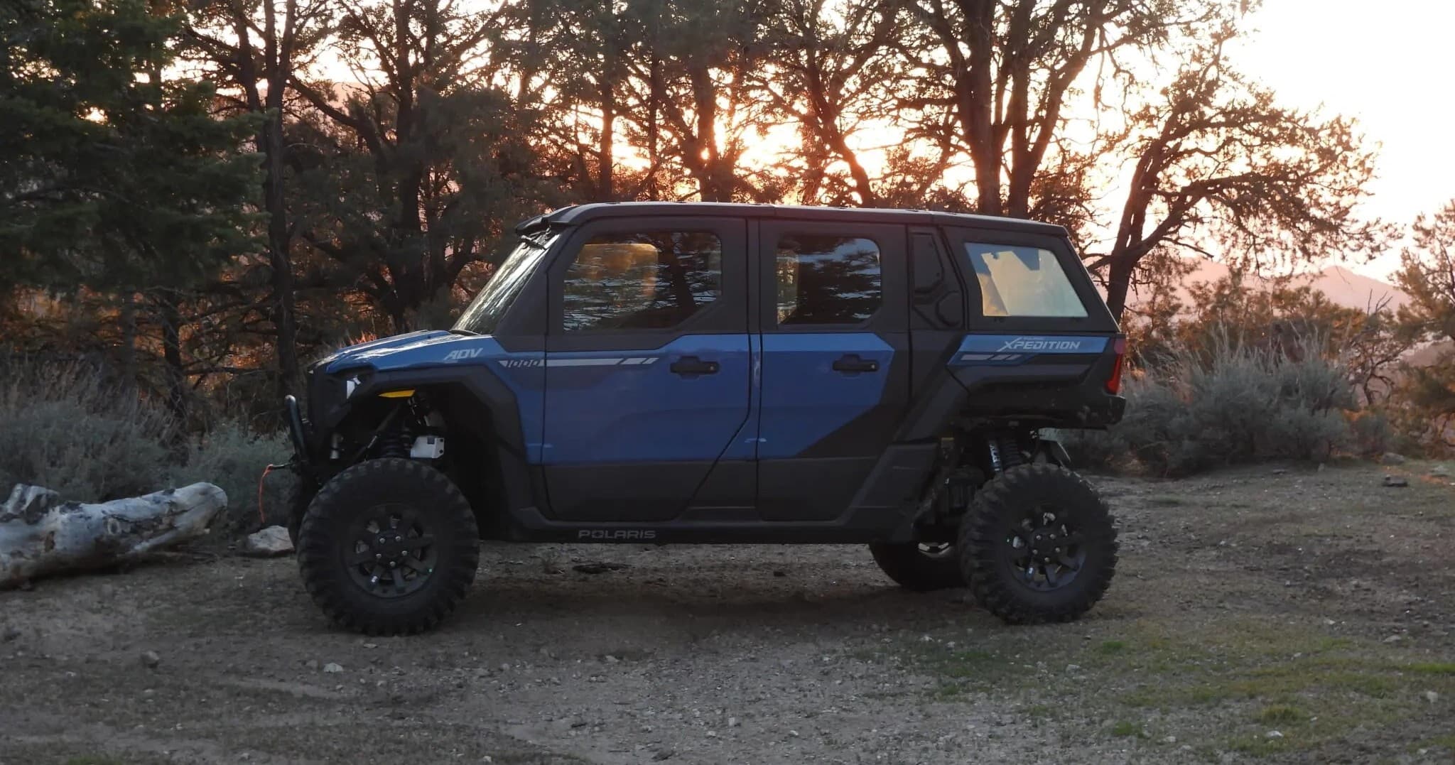 Off-road UTV parked at forest campsite during sunset outing
