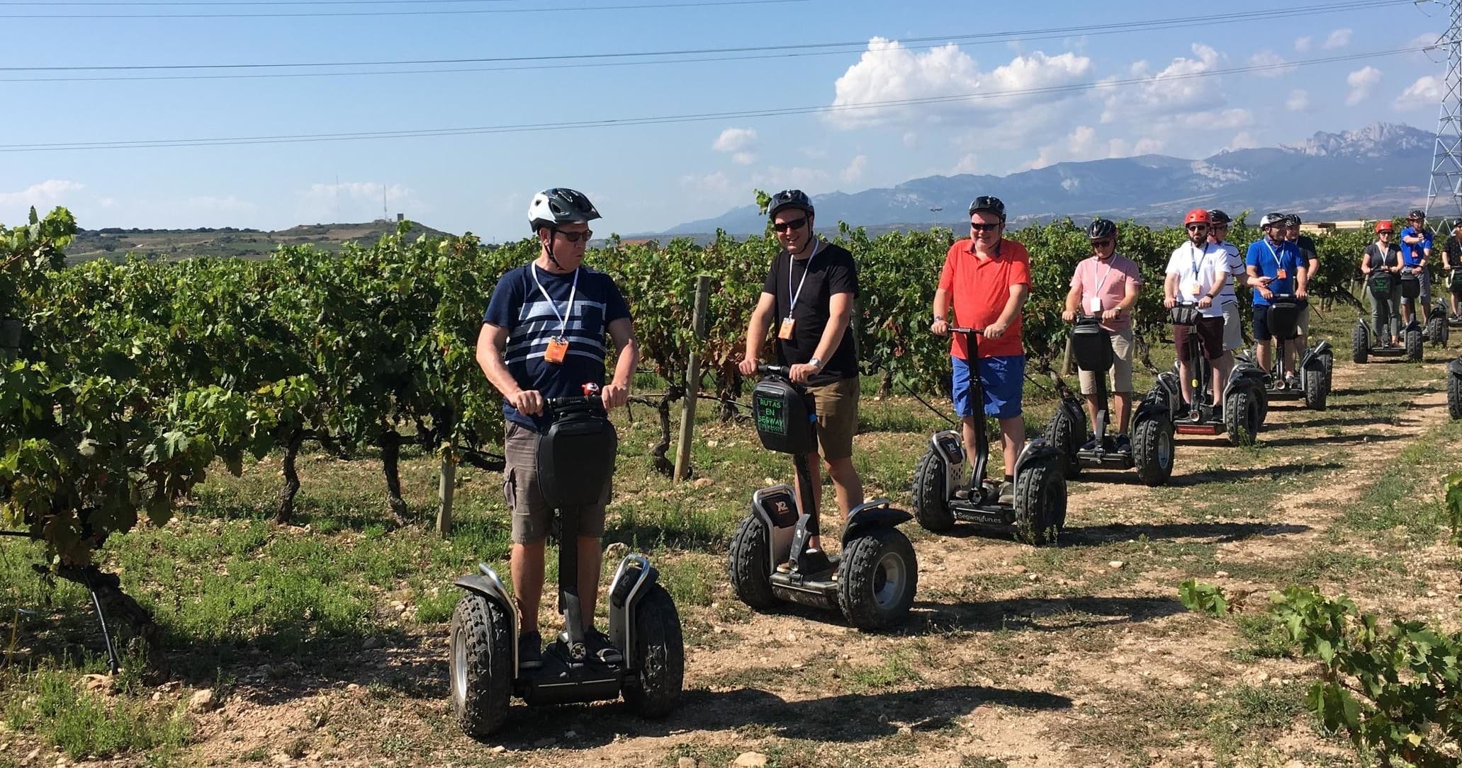 Segway tour group riding down rural dirt road through vineyards