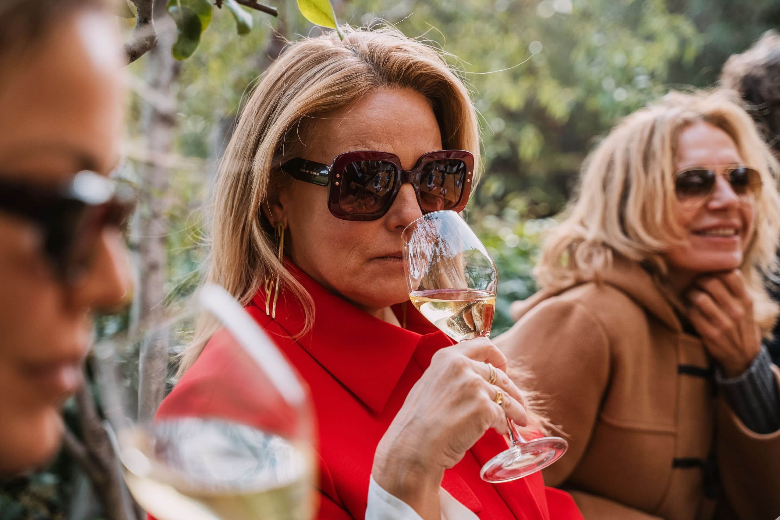 Guests enjoying outdoor wine tasting and socializing in garden at Bellesguard
