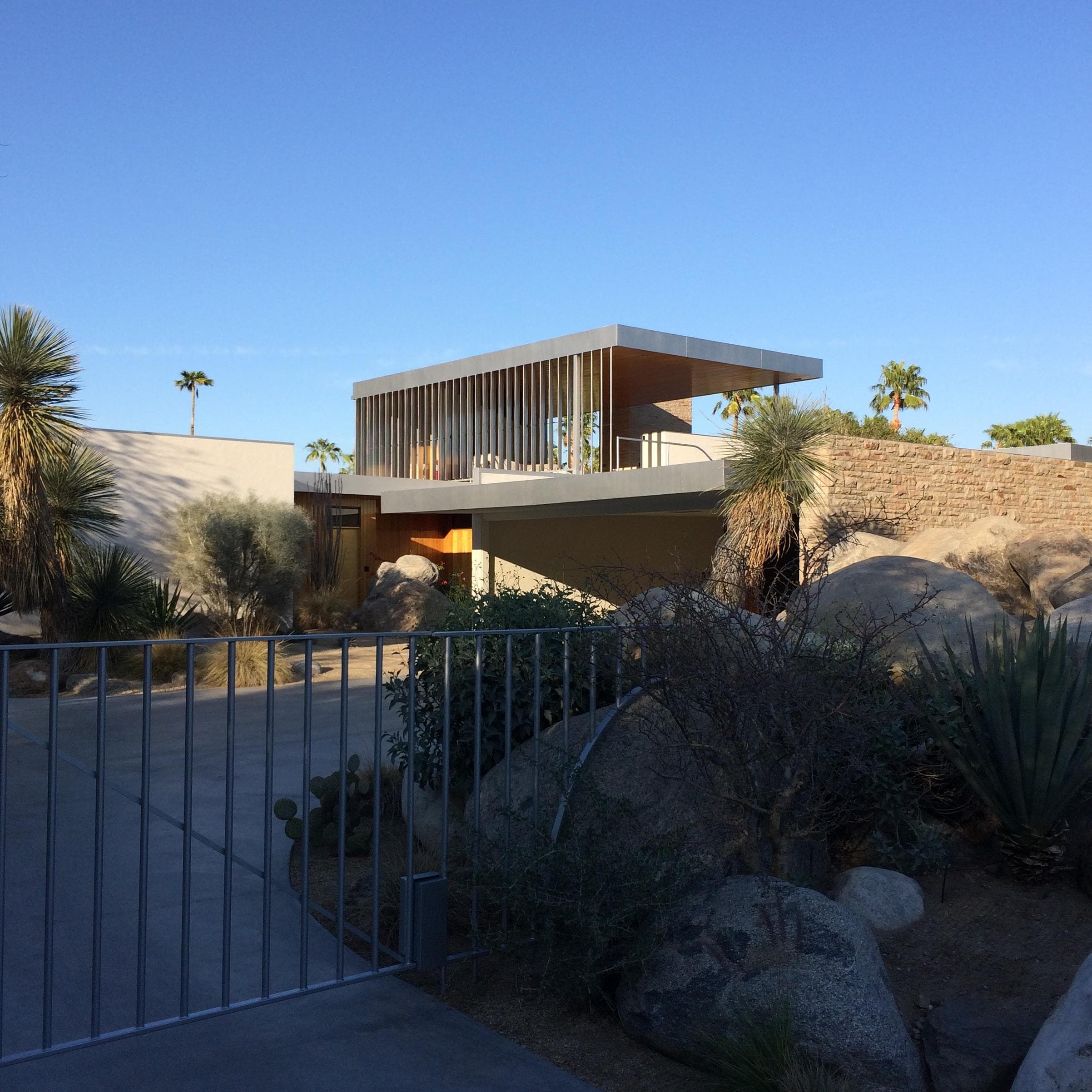 Modern desert house with palms and sunset sky in Palm Springs