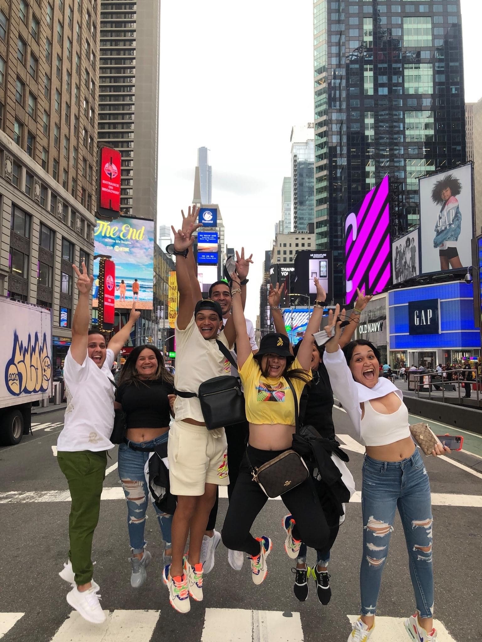 Group of tourists jumping on Times Square crosswalk, NYC walking tour