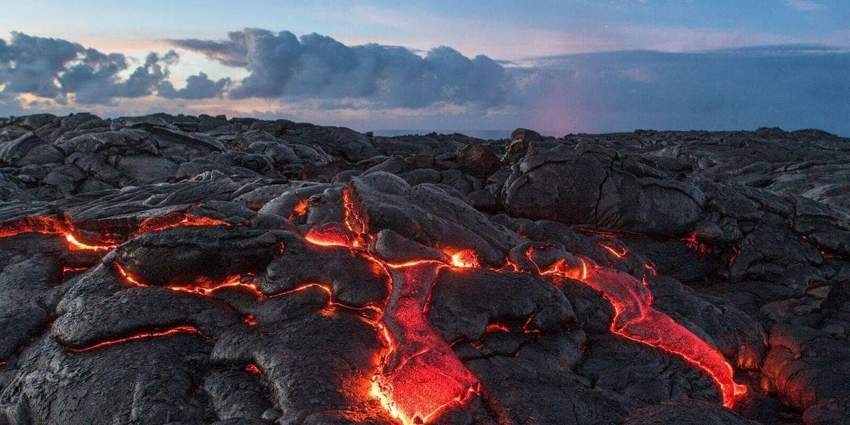 Molten lava flow across volcanic rock on Hawaiian coastline