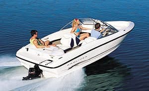 Friends enjoying speedboat ride over blue coastal waters