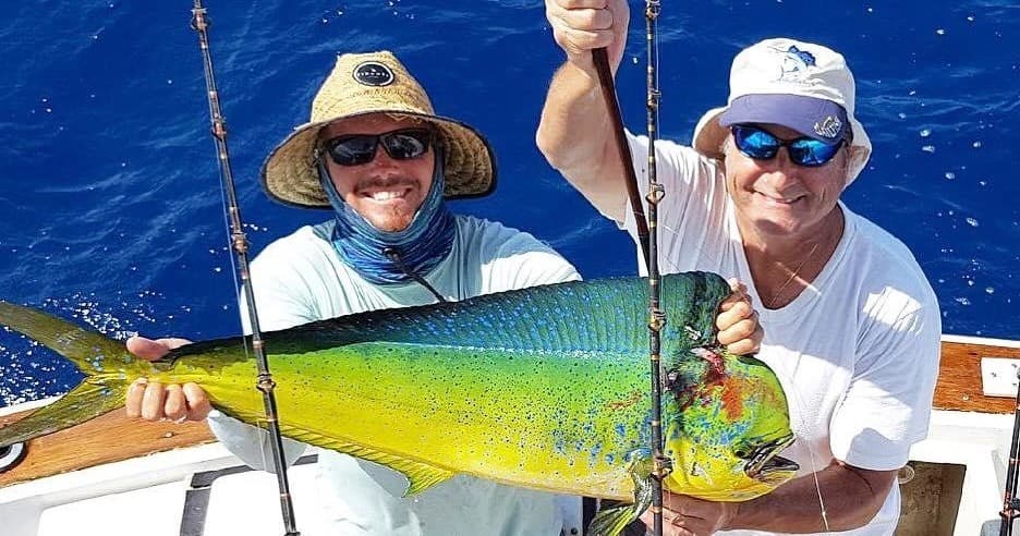 Happy anglers displaying large mahi mahi on deck during Key West charter