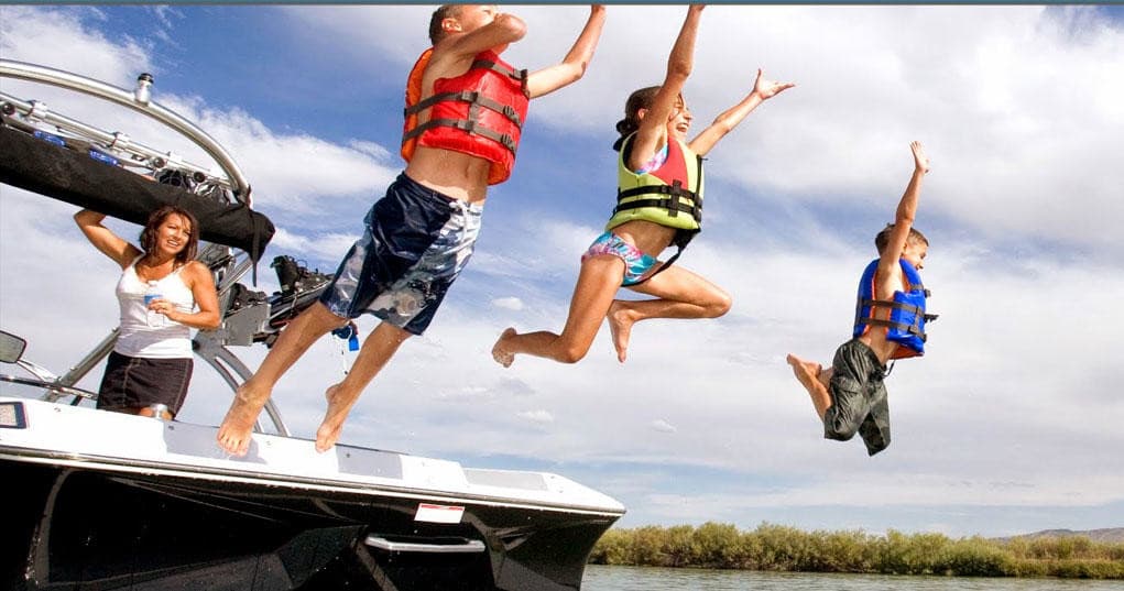 Group jumping from boat into lake for summer water adventure