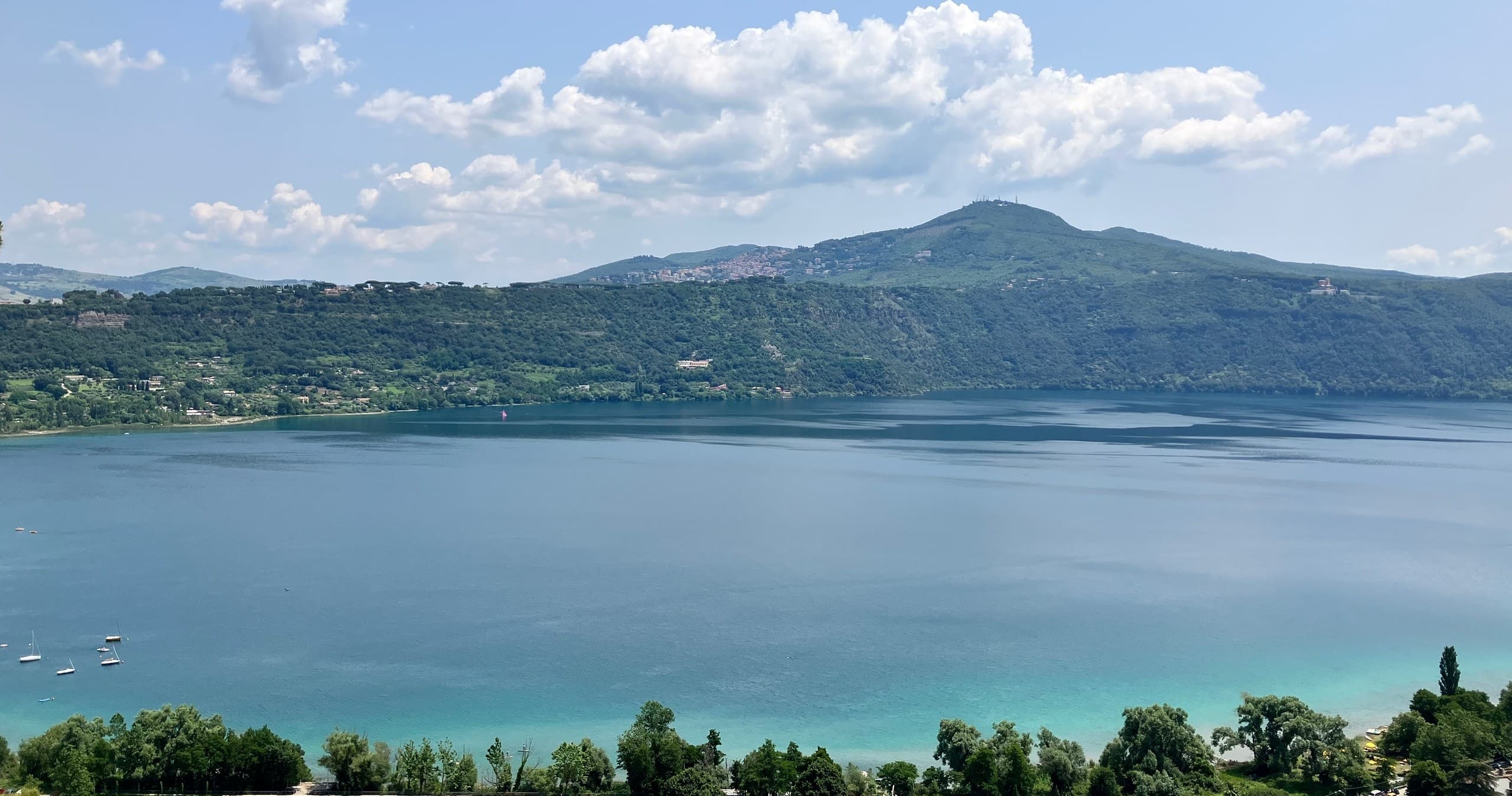 Panoramic lake view with hikers overlooking blue volcanic lake