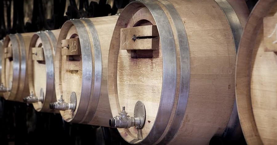 Oak wine barrels aging in cellar at historic vineyard winery