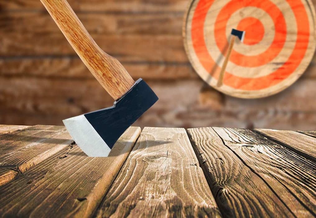 Axe throwing at rustic wooden target and platform, axe embedded