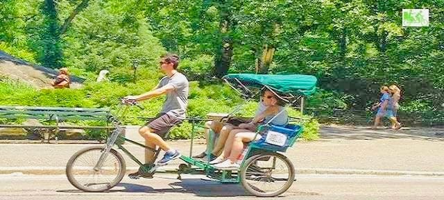 Two-person rickshaw cruising tree-lined Central Park path