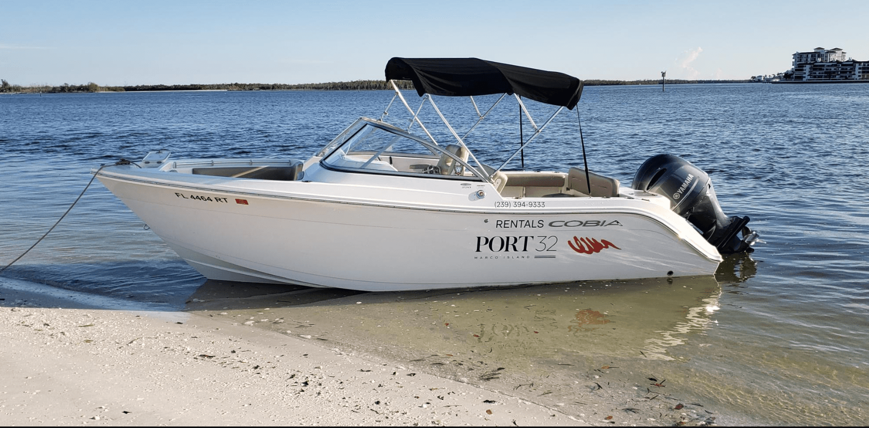 Stern-mounted outboard boat pulled ashore, coastal island waters