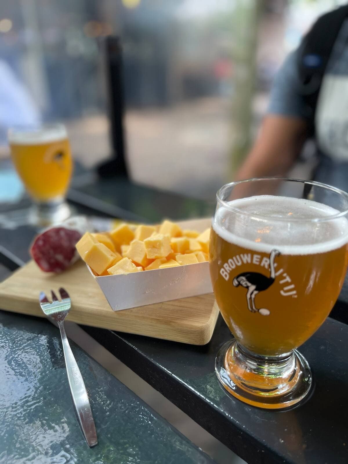 Craft beer and cheese board at outdoor Amsterdam cafe
