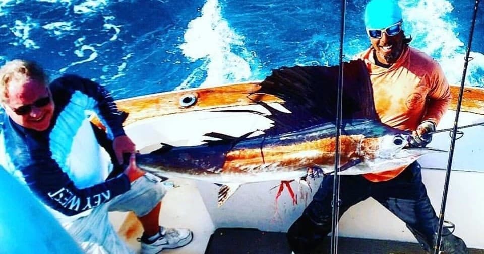 Fishermen battling blue marlin on deck during Key West offshore charter