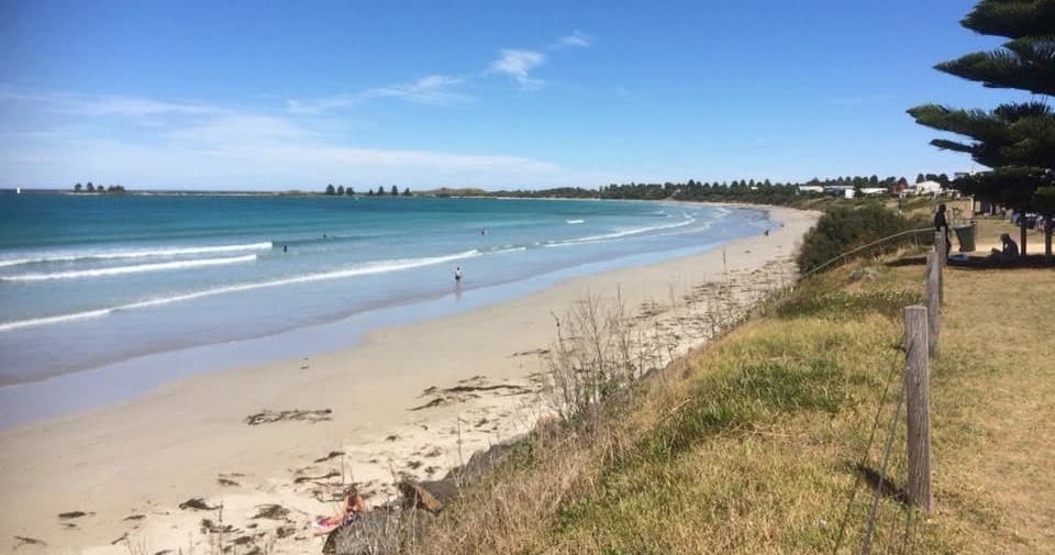 Wide sandy beach and coastal path at Port Fairy with blue sky