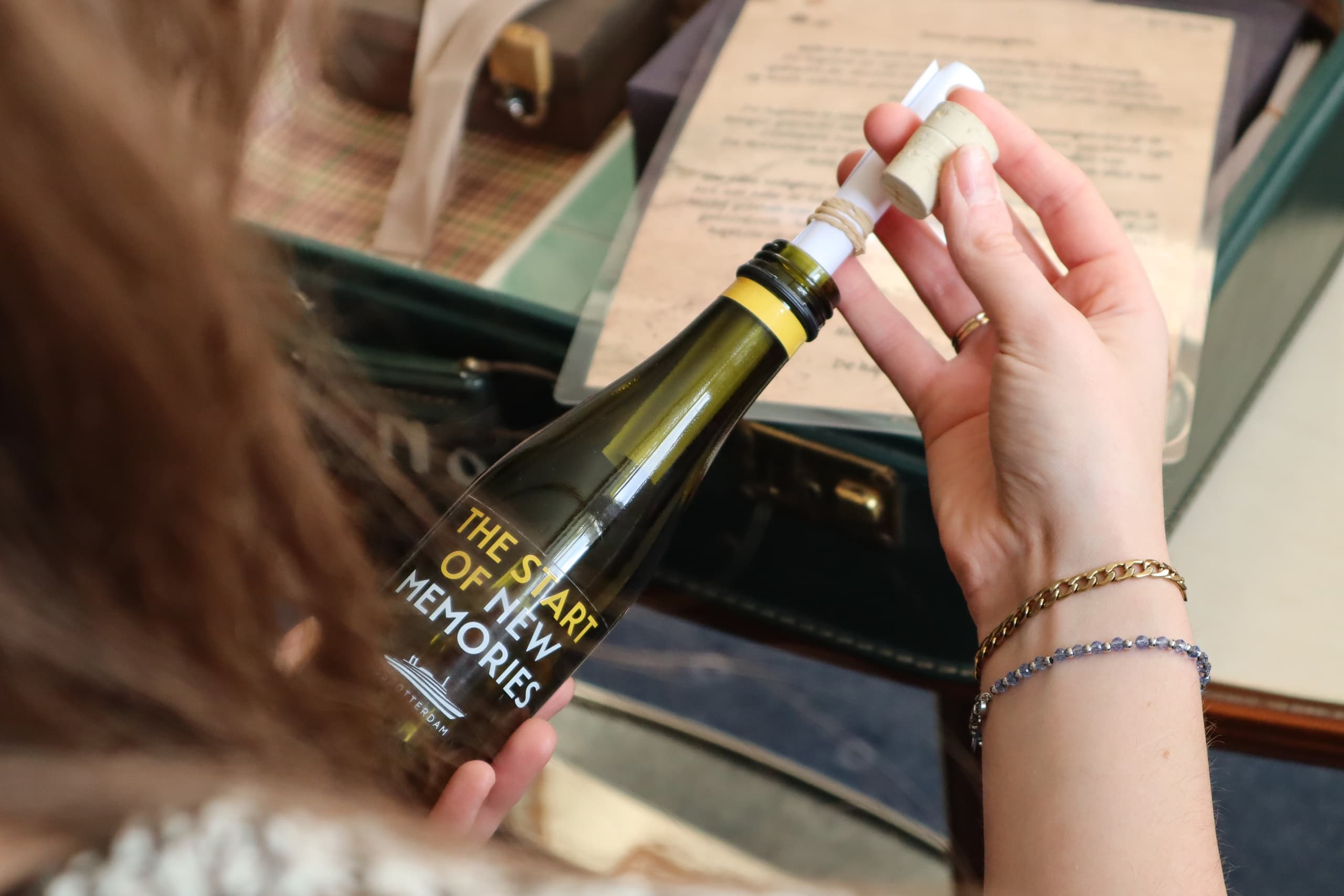Guest inspecting souvenir bottle aboard SS Rotterdam ship interior