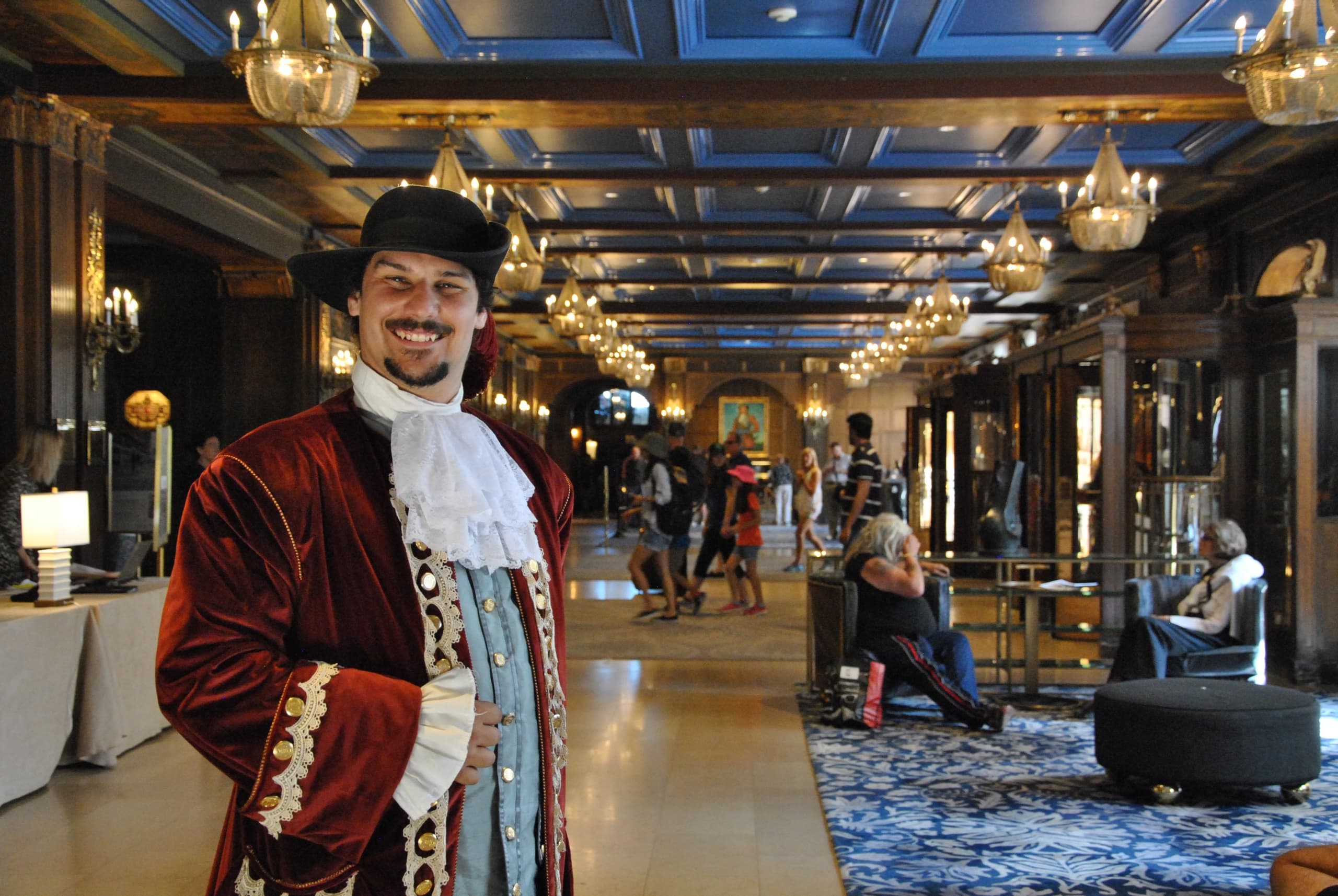 Costumed guide posing in ornate hotel lobby during heritage tour