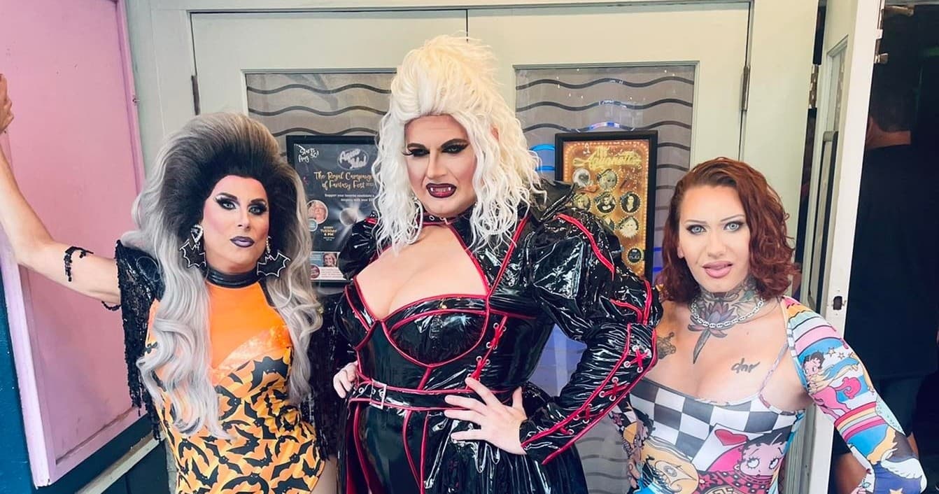Drag performers posing at Key West venue entrance indoors