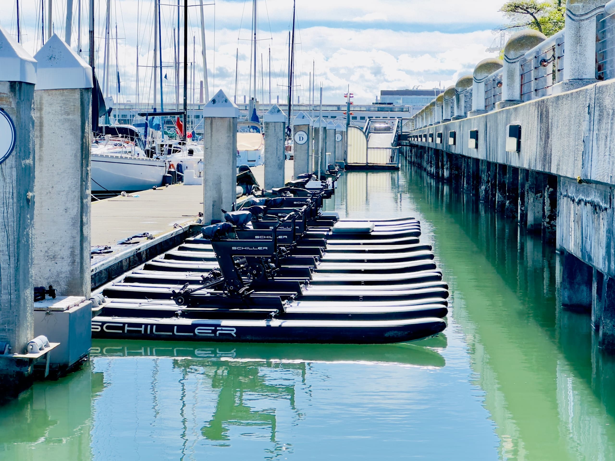 Inflatable kayaks moored in marina channel with sunny reflections
