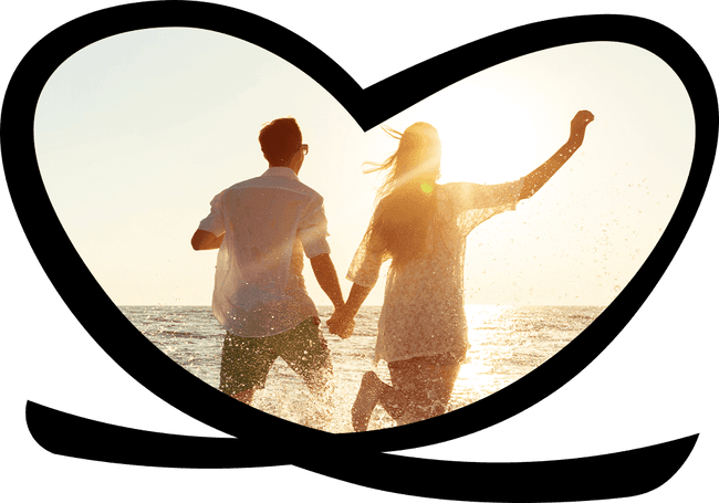 Couple splashing through surf at golden sunset on beach