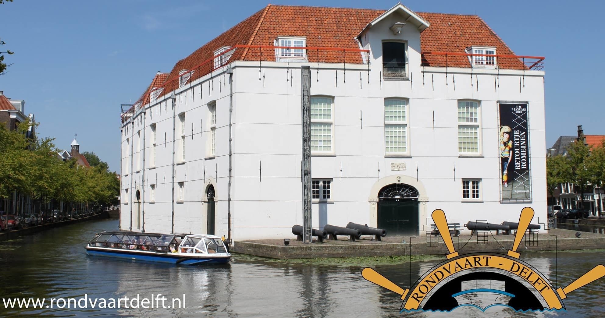 Historic waterfront building along Delft canal with boat views