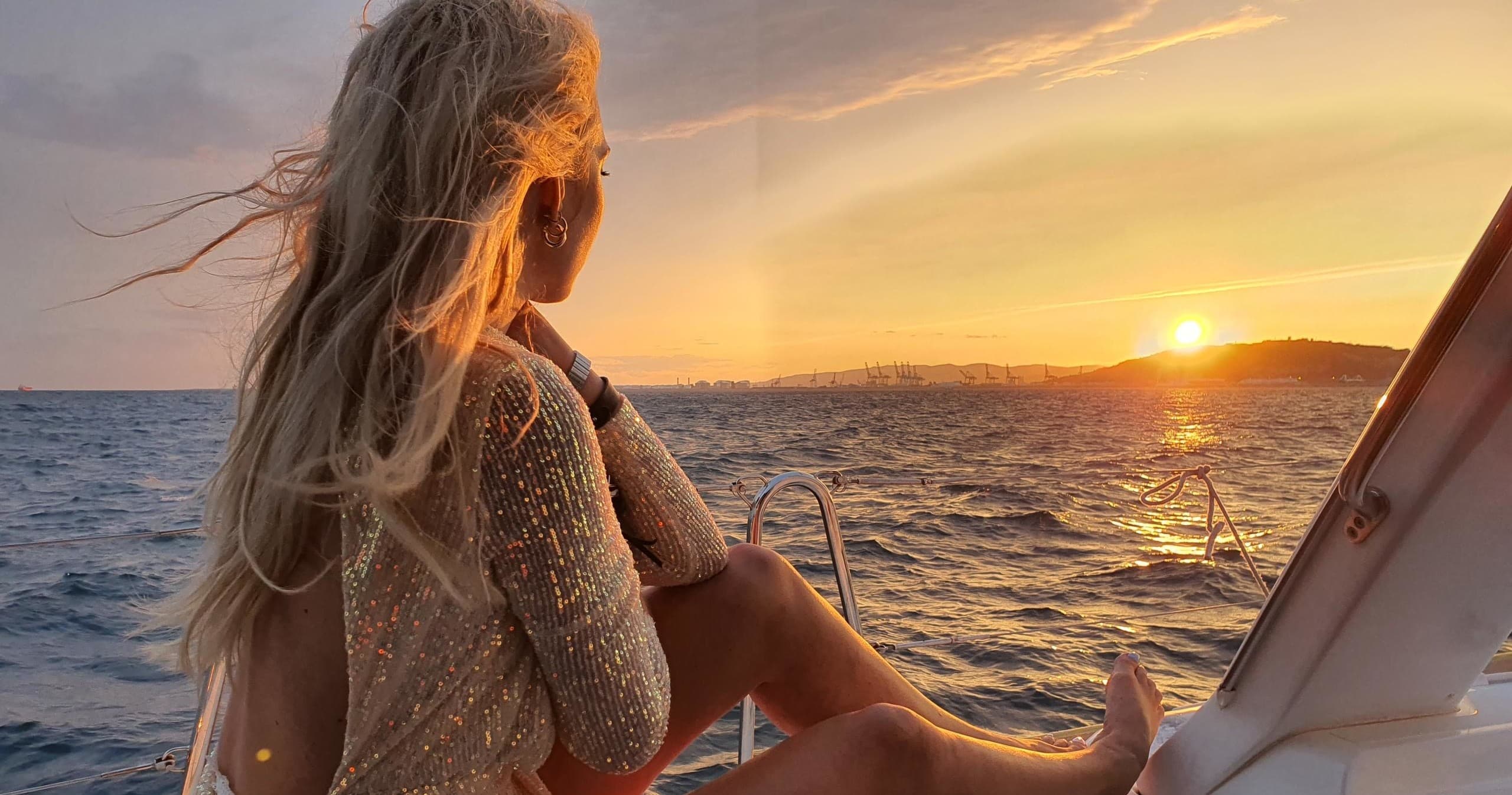 Passenger enjoying sunset view from sailboat deck in Barcelona