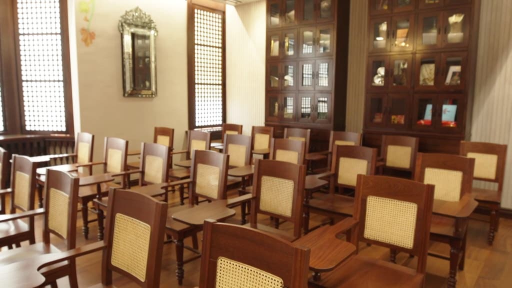 Seating for cultural lecture in ornate heritage room interior