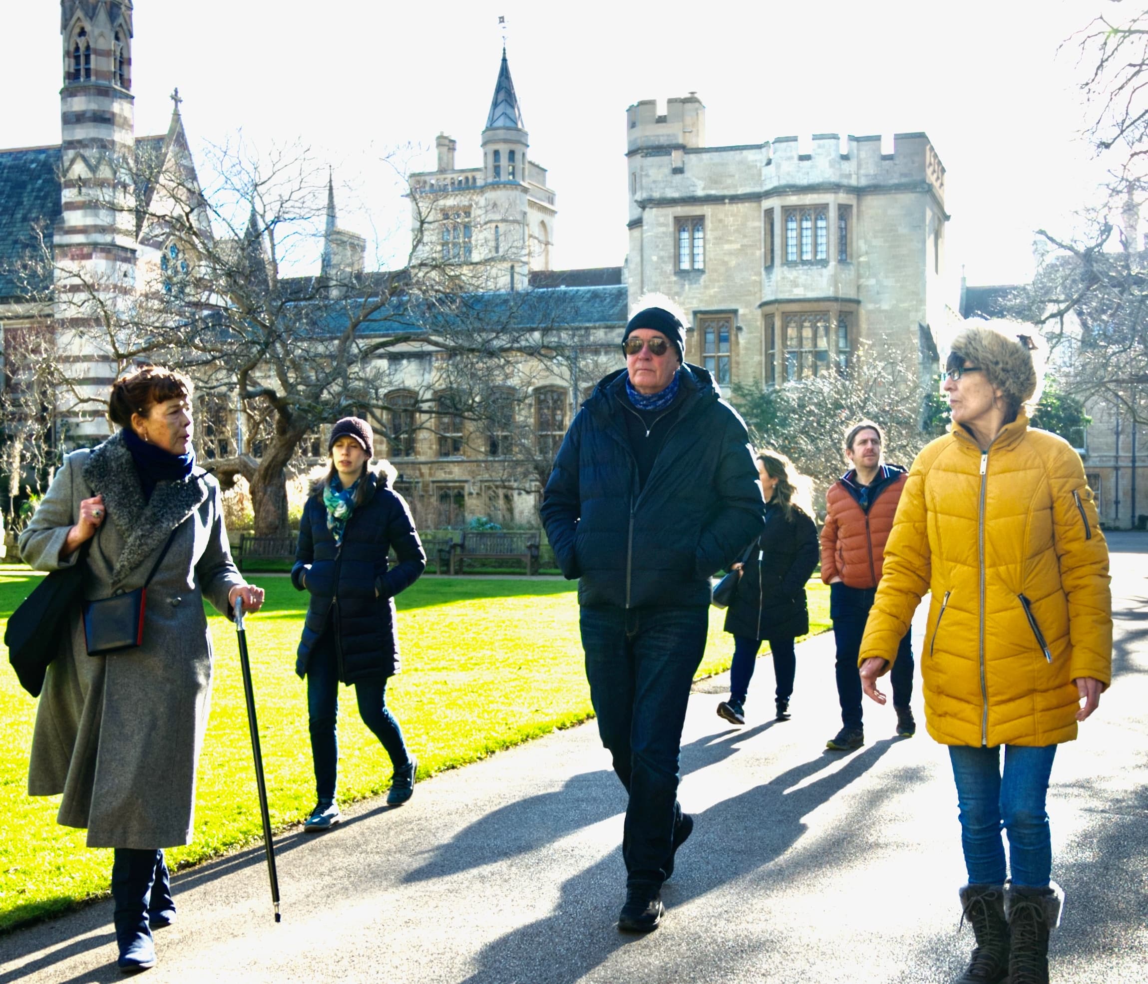 Guided walking tour across Oxford college lawns on sunny day