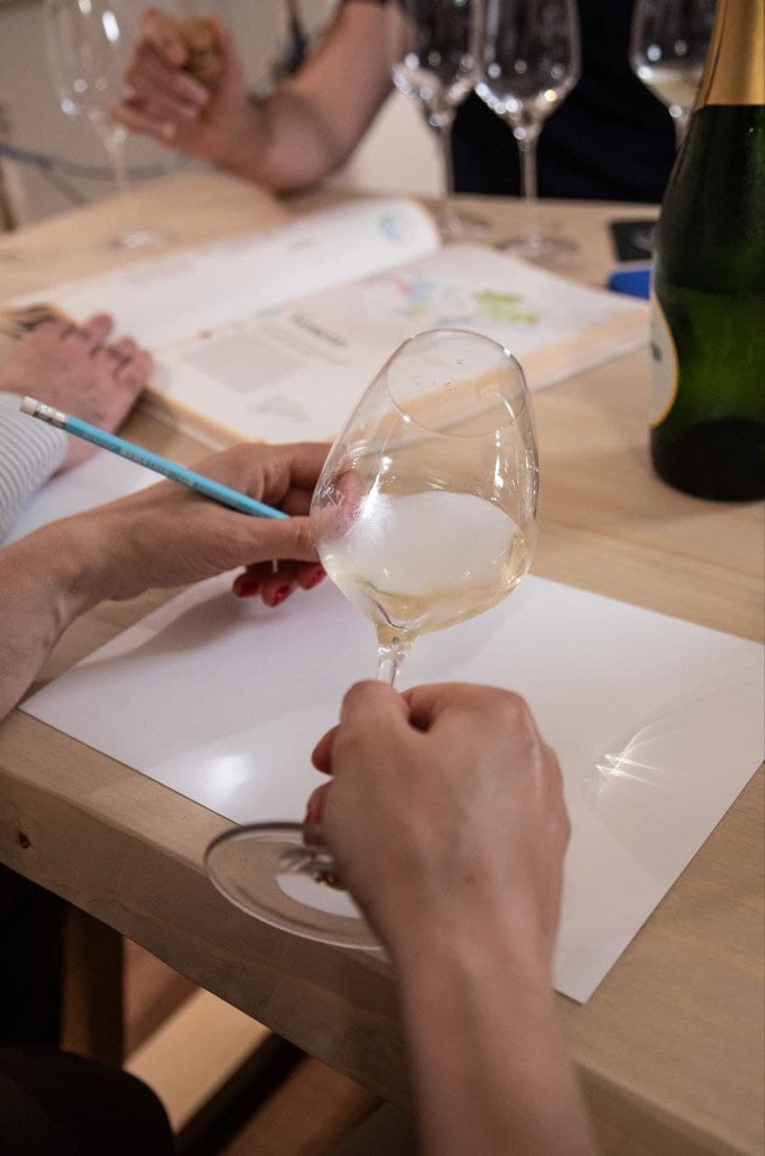 Guests tasting sparkling wine at indoor enoteca wine tasting
