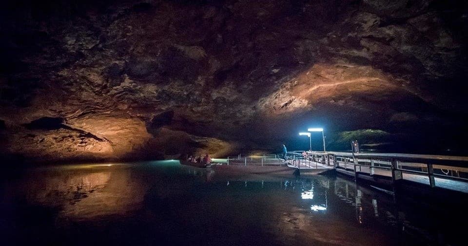 Underground lake cave tour with illuminated boardwalk in cavern