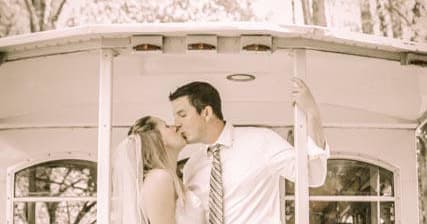 Couple kissing on historic trolley platform in sepia tone