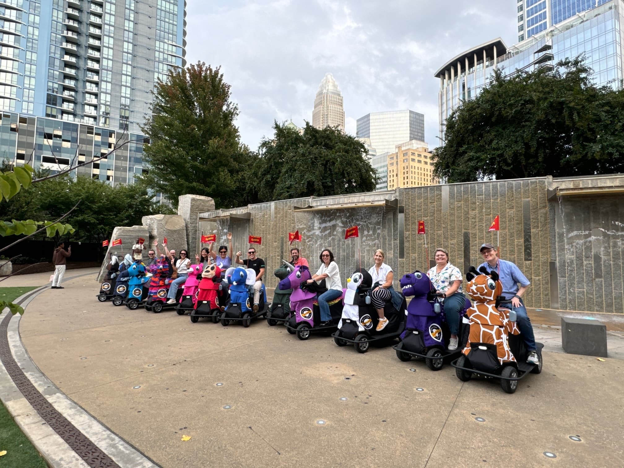 Group of mobility scooters lined up in urban park near skyline